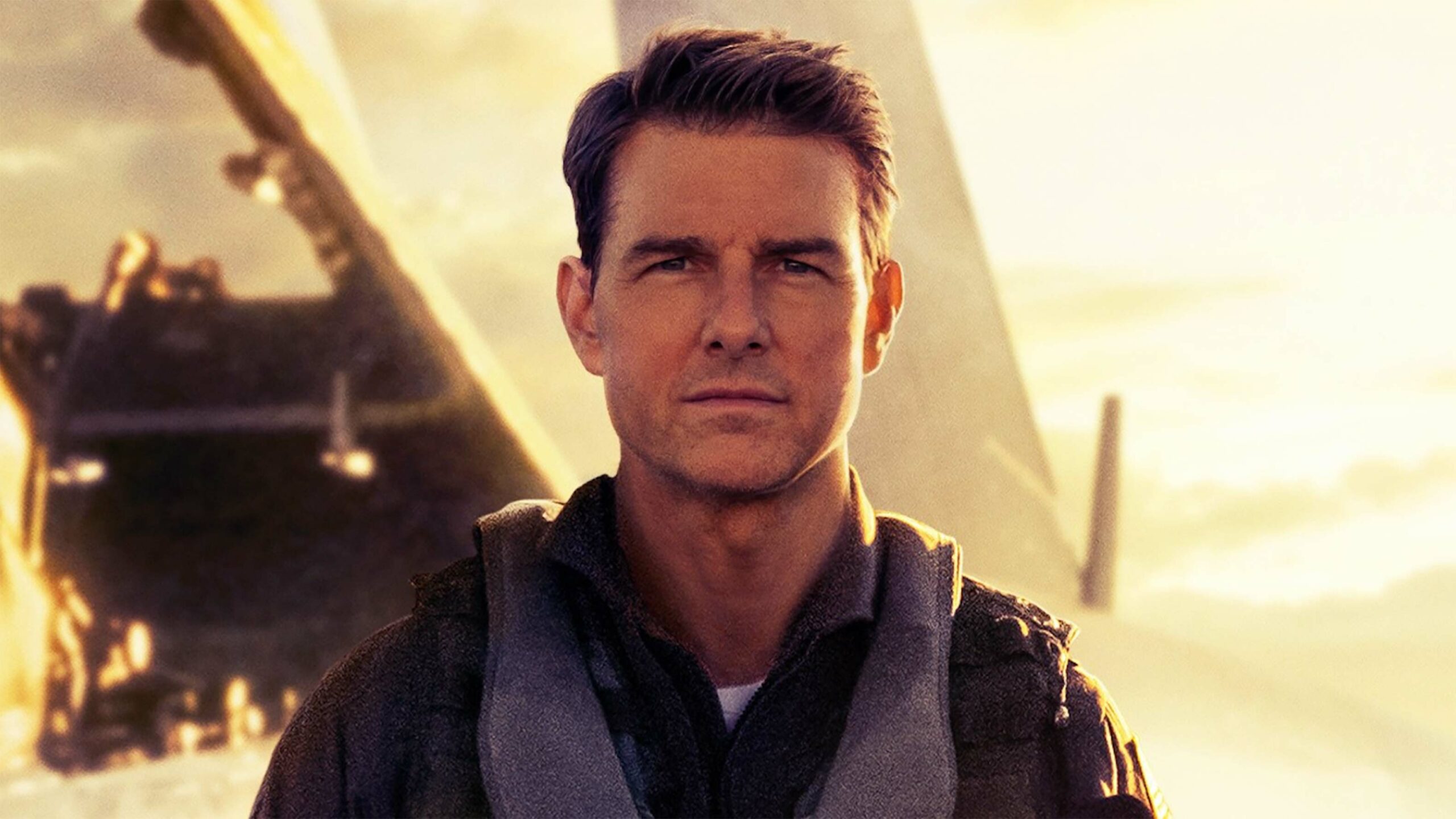 Top Gun: Maverick poster featuring Tom Cruise walking on a carrier with the sun and a plane behind him.