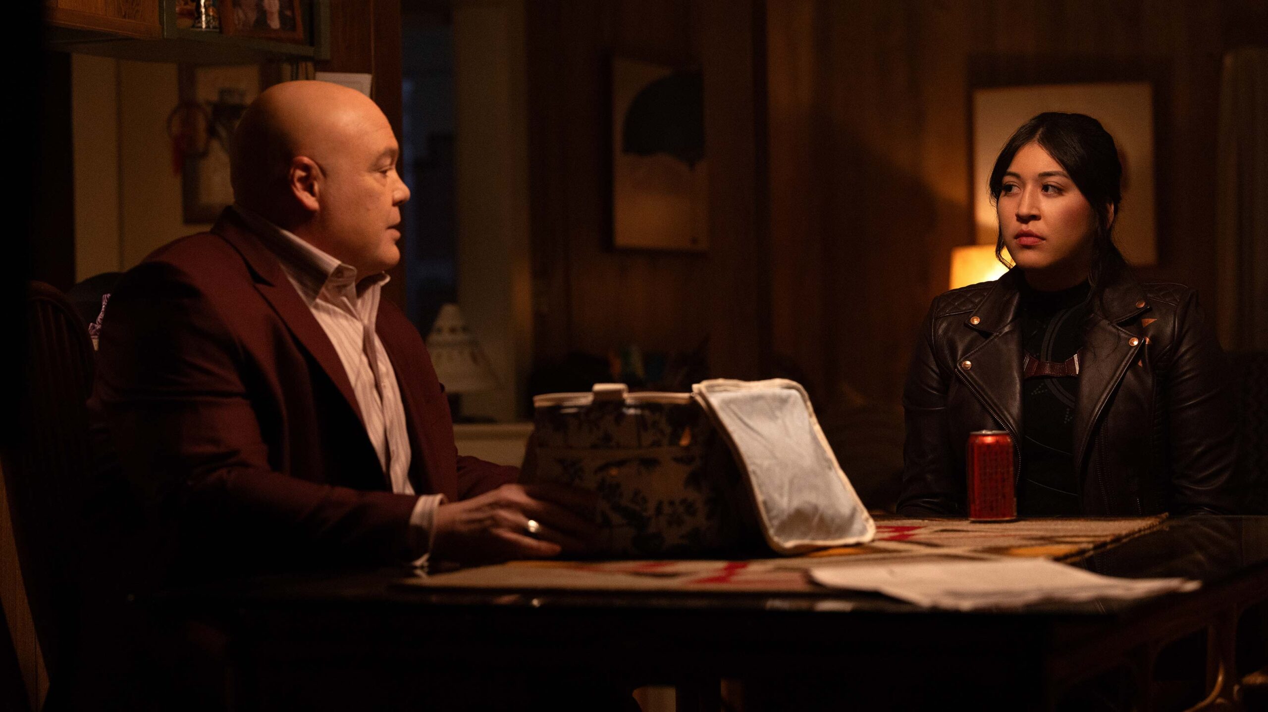 Kingpin talks to Maya at a dinner table in Echo.