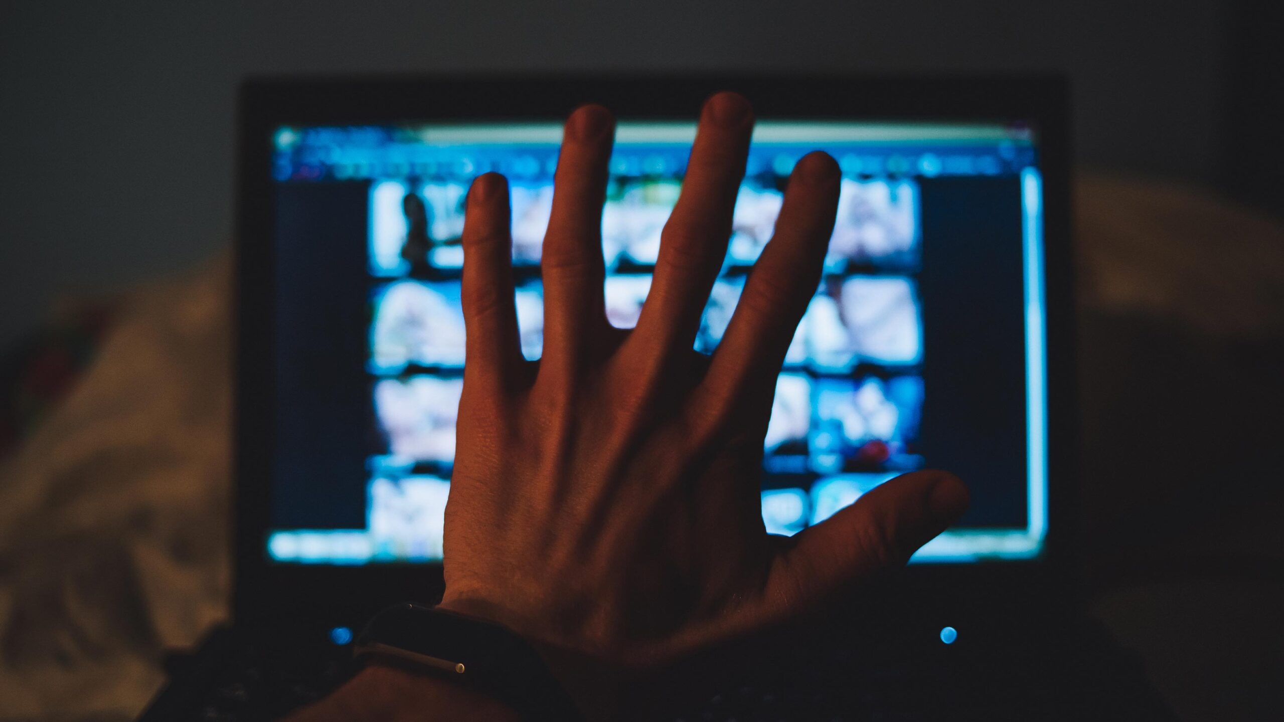 guy hiding porn on computer with hand
