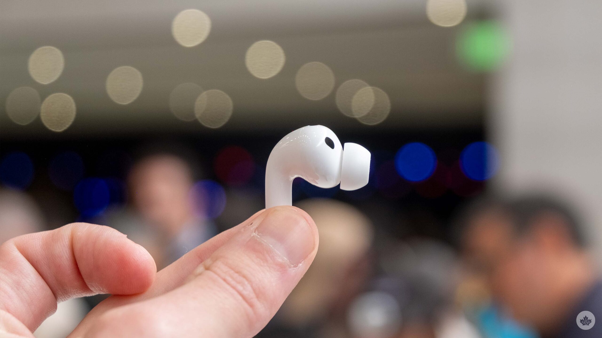 A hand holding the Apple AirPods Pro 3