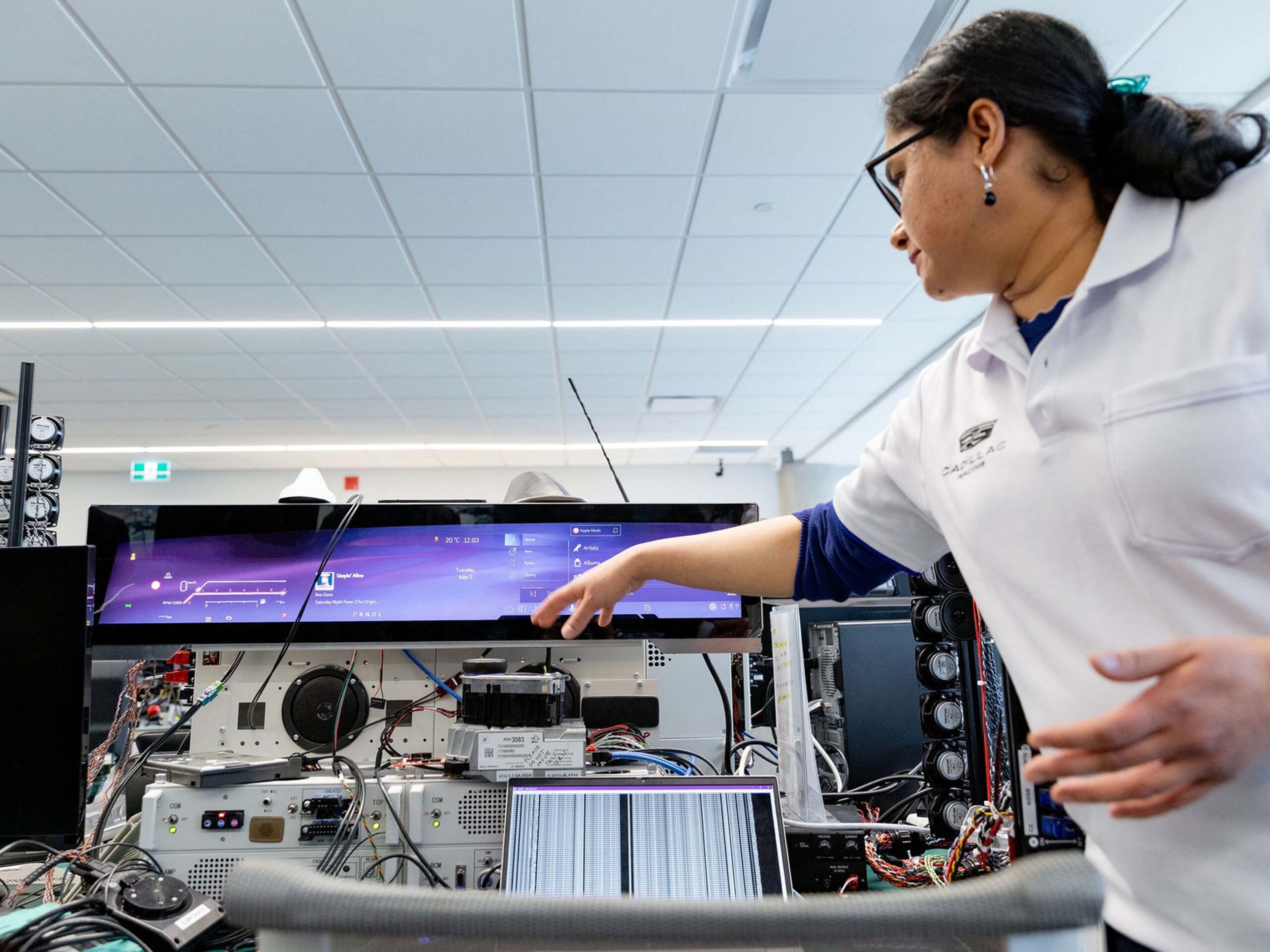 A GM Engineer pointing to an infotainment screen
