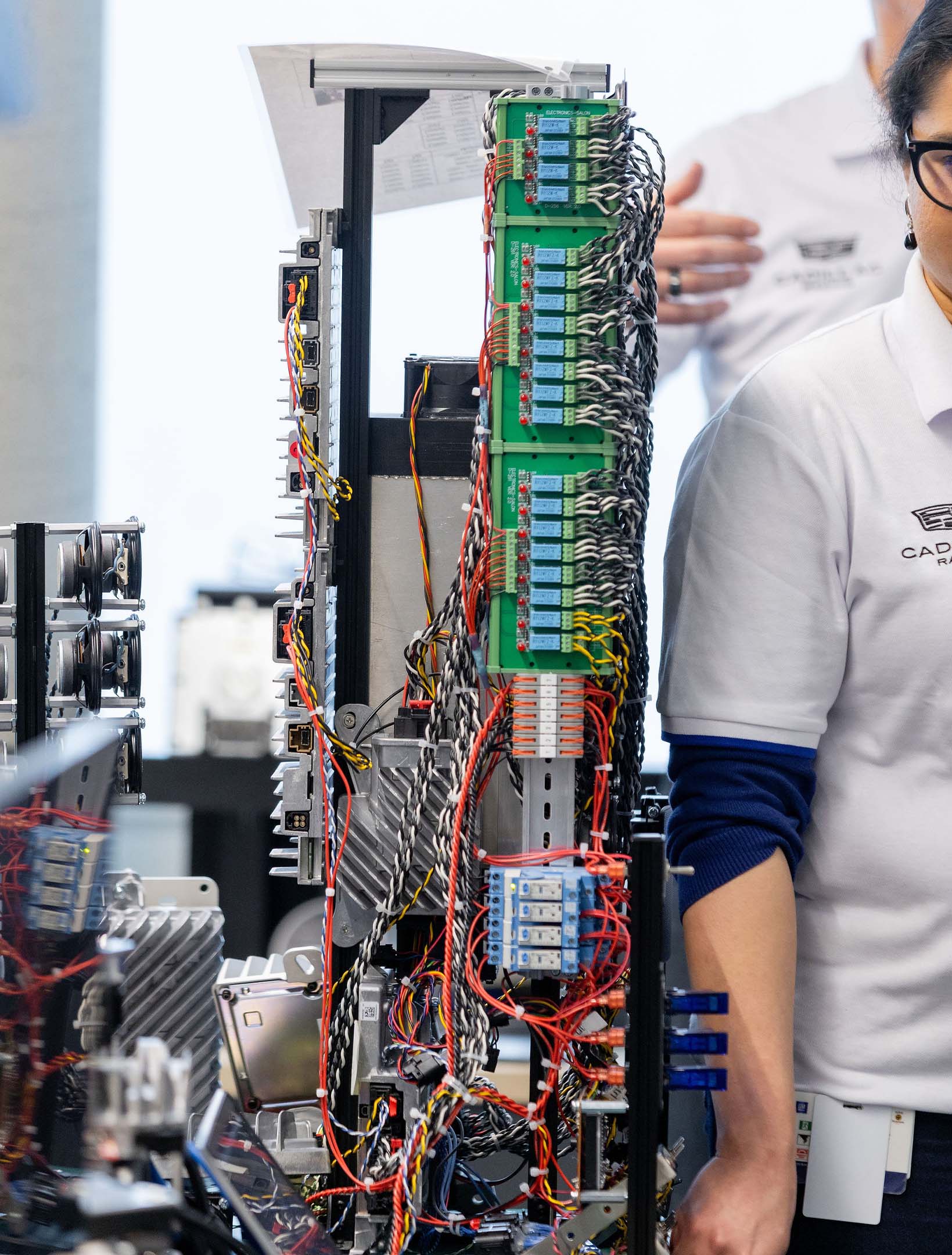 A GM Engineer standing next to a tower of speakers at the General Motors Markham Elevation Centre