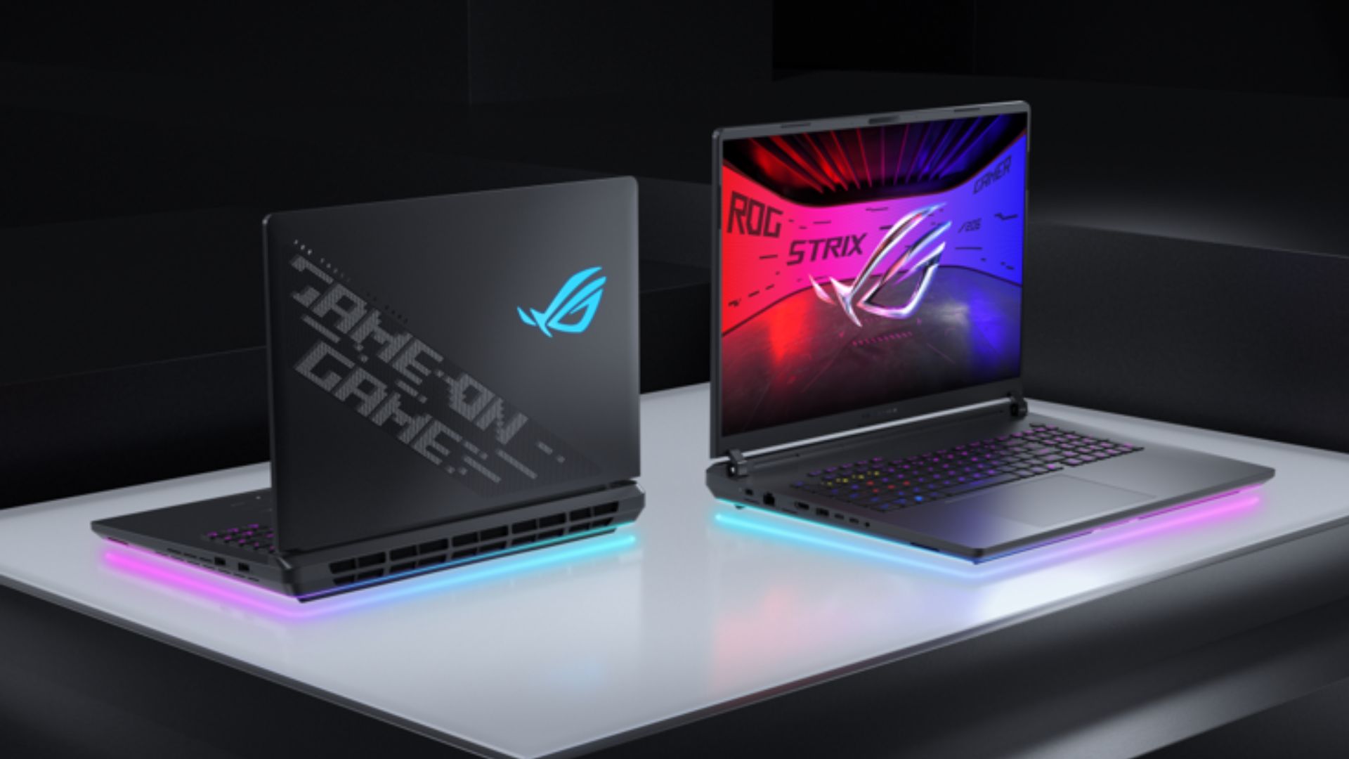 two ASUS gaming laptops under a spotlight